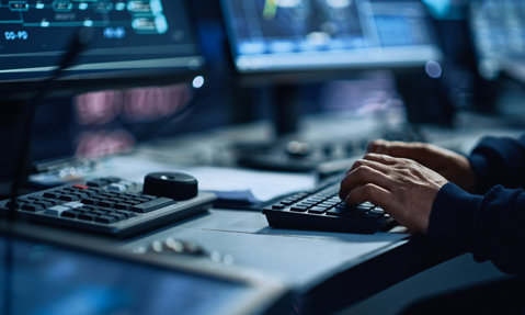 Hands on a keyboard with additional computer accessories visible